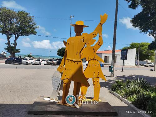 a statue of a man in a yellow outfit at Flat no Coração de Tambaú - 123Quarto Hospedagem in João Pessoa