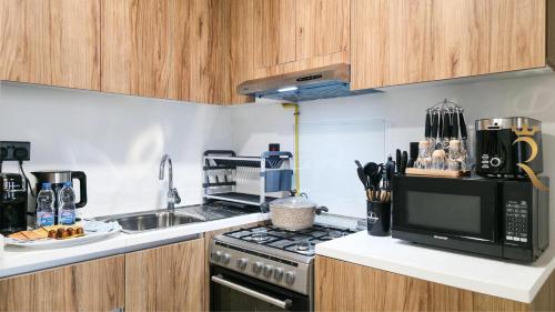 a kitchen with a stove and a microwave at Stylish 1BR - Maryah Vista Luxe Escape in Abu Dhabi