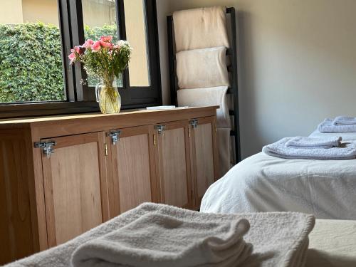 a bedroom with a vase of flowers on a window at Clivias Hostel in Salta