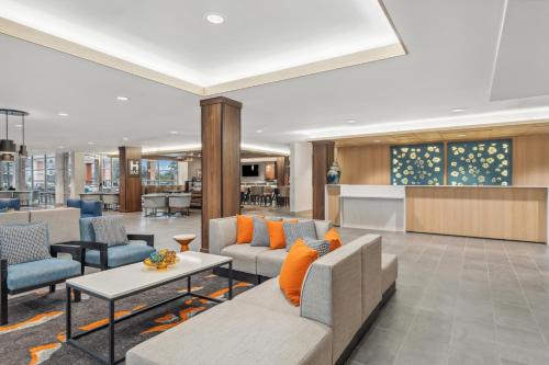 a lobby with a couch and chairs and a table at Hyatt House Orlando International Drive in Orlando
