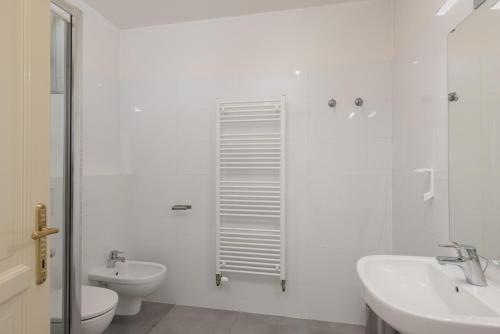 a white bathroom with a toilet and a sink at Salvatore Prague Rooms in Prague