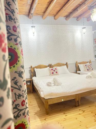 a bedroom with two beds with white sheets at Old town guest house in Bukhara