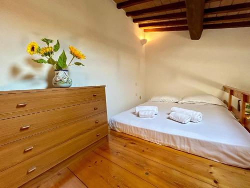 a bedroom with a bed and a vase with flowers at La Loggetta dei Poderi - 5' dalle Terme di Saturnia in Montemerano