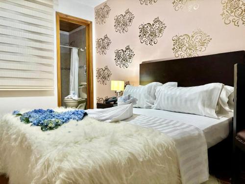 a bedroom with a large white bed with blue flowers on it at Casa Coliving 121 in Bogotá