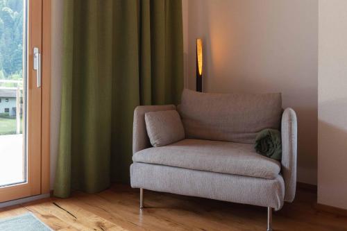 a chair sitting in a room next to a window at Appartement Pension Strolz in Bichlbach