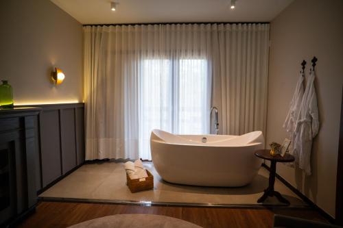 a bathroom with a large tub in front of a window at Natureza Eco Lodge in Pedra Azul