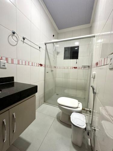 ein weißes Badezimmer mit Toilette und Dusche in der Unterkunft Davisis - Casa Ampla 2 Quartos e Garagem grande in Palmas