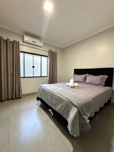 ein Schlafzimmer mit großem Bett und Fenster in der Unterkunft Davisis - Casa Ampla 2 Quartos e Garagem grande in Palmas