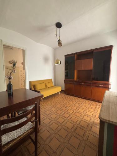 a living room with a yellow couch and a television at Casa Emma Homestay in Alba city center in Alba