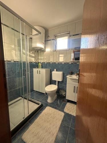 a bathroom with a toilet and a glass shower at Apartmani Kostić Gračanica-Kosovo in Gracanica