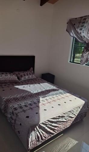 Un dormitorio con una cama con una manta encima. en Casa quinta Clara, en Limpio