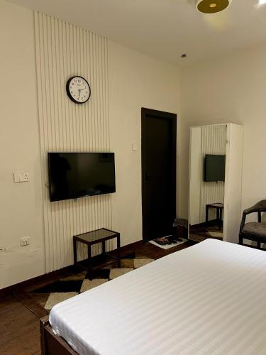 a bedroom with a bed and a clock on a wall at Lyallpur Home Stay in Faisalabad