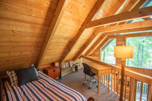 a bedroom with a bed and a desk in a cabin at Fleetwood Falls Cabin near Boone- Community River & Lake Access, Dogs OK in Fleetwood