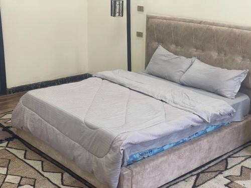 a bed with white sheets and pillows in a room at Panoramic Three Bedrooms Apartment in Addis in Addis Ababa