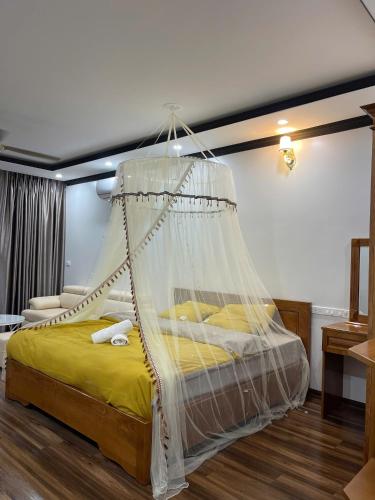 a bedroom with a bed with a mosquito net at Đầm sen Resort in Hòa Lạc