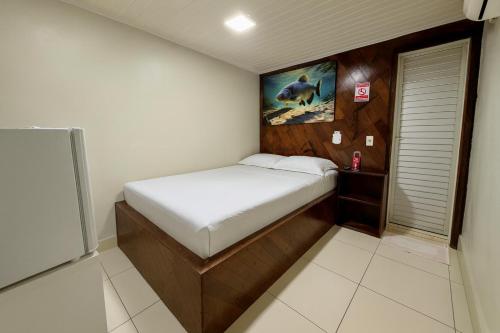 a small bedroom with a bed and a painting on the wall at Hotel COP 30 in Belém