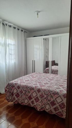 a bedroom with a bed and a mirror in it at Casa da Marlene in Resende