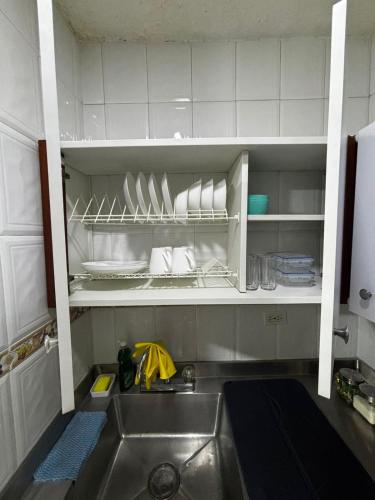 a kitchen with a sink and a shelf with dishes at Apto 201 2H 2B Belén Fátima MUY bien ubicado in Medellín