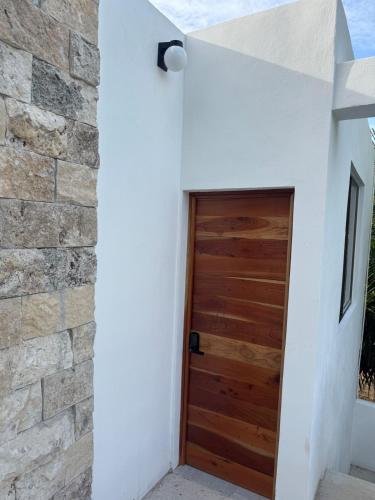 a door in a white building with a stone wall at Lindo depto 2 piso cerca de la playa in Chabihau