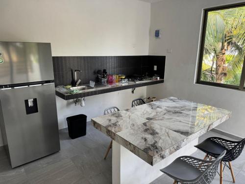 a kitchen with a marble counter top and a refrigerator at Lindo depto 2 piso cerca de la playa in Chabihau