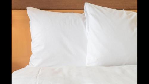 a stack of white pillows on a bed at Holiday Inn Express Hotel & Suites Dubois by IHG in DuBois