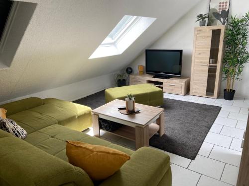 a living room with a couch and a tv at Ferienwohnung am Erbacher Mümlingufer in Erbach im Odenwald