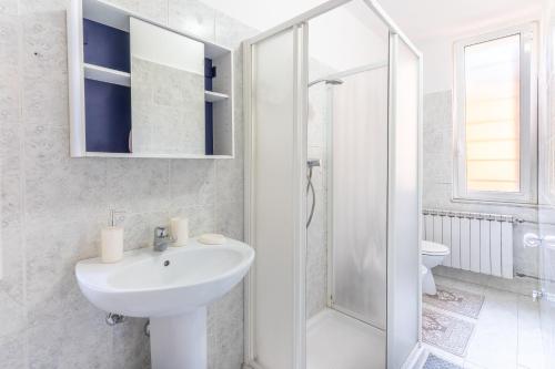 a white bathroom with a sink and a shower at Zen Retreat with Jacuzzi, Patio & Private Garage Plus Automatic Check in 24 7 with Netflix Dazn and Disney Plus in Casale Monferrato