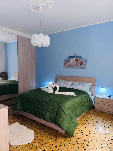 a bedroom with a green bed with two swans on it at Profumo di Sicilia Augusta in Augusta