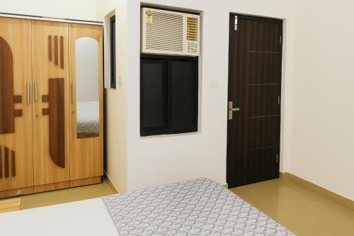 a bedroom with a bed and a window and a door at Patron Stay in Vrindāvan