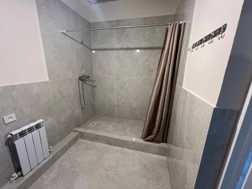 a bathroom with a shower with a shower curtain at Guest house Stella in Cholpon-Ata
