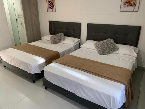 two beds in a hotel room withthritisthritislictslictslicts at Apartamento Cartagena en el laguito bocagrande vista al mar in Cartagena de Indias