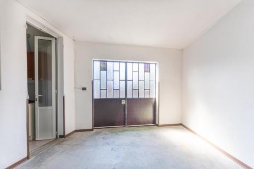 an empty room with a door and a window at Zen Retreat per Coppie con Jacuzzi - Dehor e Garage Privato - Check in Automatico 24 7 in Casale Monferrato