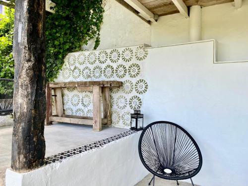 a black chair sitting next to a wall with a fireplace at Eulalie ,maison de village avec jardin in Saint-Aulaye