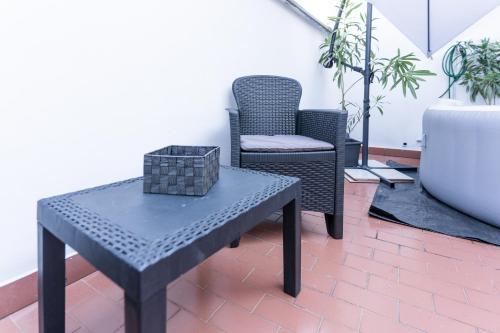 a table and a chair with a box on a patio at Zen Retreat per Coppie con Jacuzzi - Dehor e Garage Privato - Check in Automatico 24 7 in Casale Monferrato