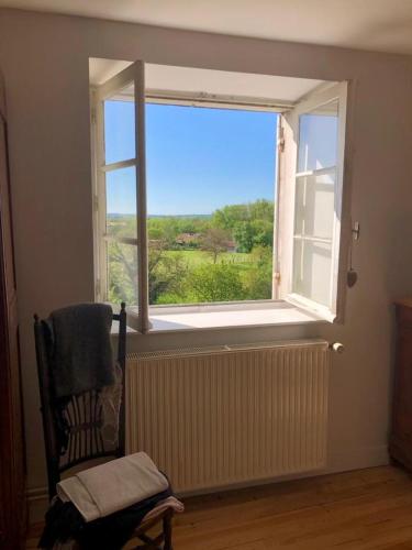 a window in a room with a chair in front of it at Eulalie ,maison de village avec jardin in Saint-Aulaye