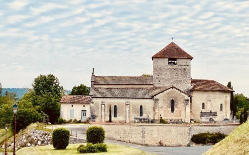 an old stone building with a tower on a hill at Eulalie ,maison de village avec jardin in Saint-Aulaye