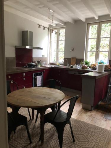 a kitchen with a wooden table and a table and chairs at Eulalie ,maison de village avec jardin in Saint-Aulaye