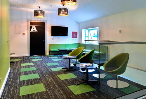 una sala de reuniones con sillas verdes y un cartel en la pared en Hostel 365 For U, en Dubrovnik