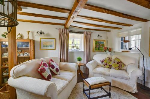 a living room with two white couches and a table at Old Beams in Stiffkey