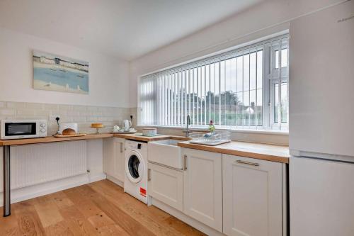 a kitchen with a sink and a washing machine at Sunbeam in Snettisham