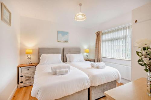 a bedroom with two beds with white sheets at Sunbeam in Snettisham