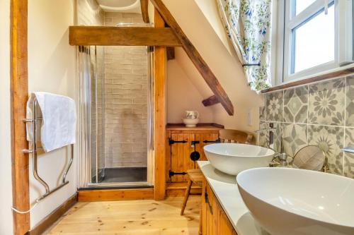 une salle de bain avec deux lavabos et une fenêtre dans l'établissement Orchard Cottage, à East Dereham