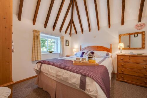 a bedroom with a bed and a dresser and a mirror at The Maltings in Ludham