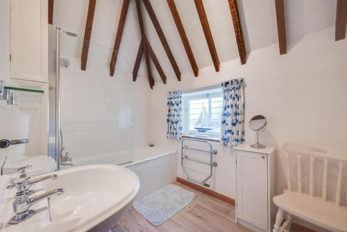 a bathroom with a sink and a tub and a shower at The Maltings in Ludham