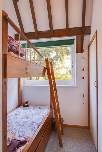 a bedroom with bunk beds and a window at The Maltings in Ludham