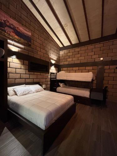 a room with two beds and a brick wall at HOTEL & RV PARK ROSA EVELYN in San Quintín