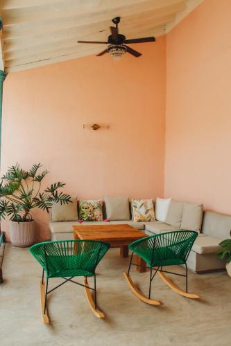 a living room with a couch and two green chairs at Casa la batuta in Santa Fe de Antioquia