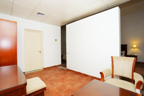 an empty room with a table and two chairs at Super Townhouse Island Inn in Cochin