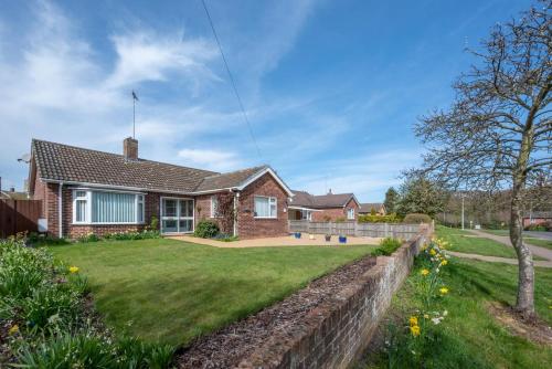 a brick house with a brick wall and a yard at Sunsette in Reydon