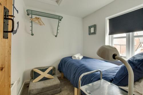 a bedroom with a bed and a chair and a window at 3 Alde Lane in Aldeburgh